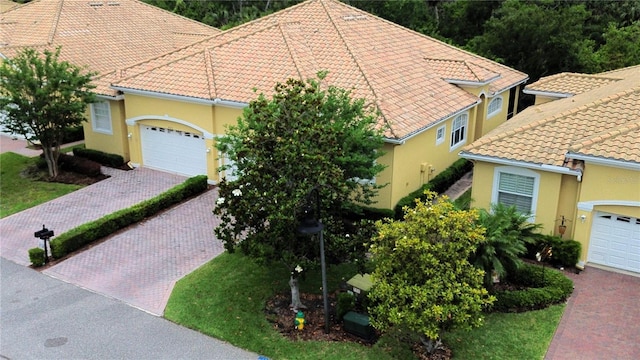 4837 Rainbow Race, New Port Richey, FL 34652 - view of front of house with stucco siding, decorative driveway, a garage, and a tile roof