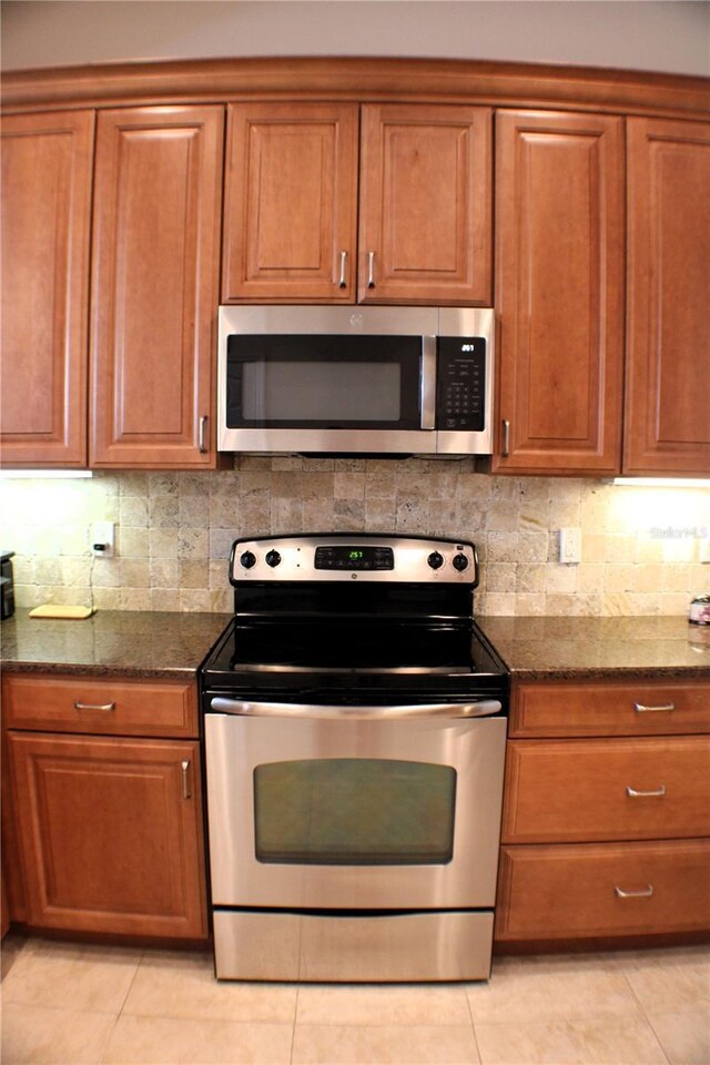 4837 Rainbow Race, New Port Richey, FL 34652 - kitchen featuring stainless steel appliances, brown cabinetry, and light tile patterned floors