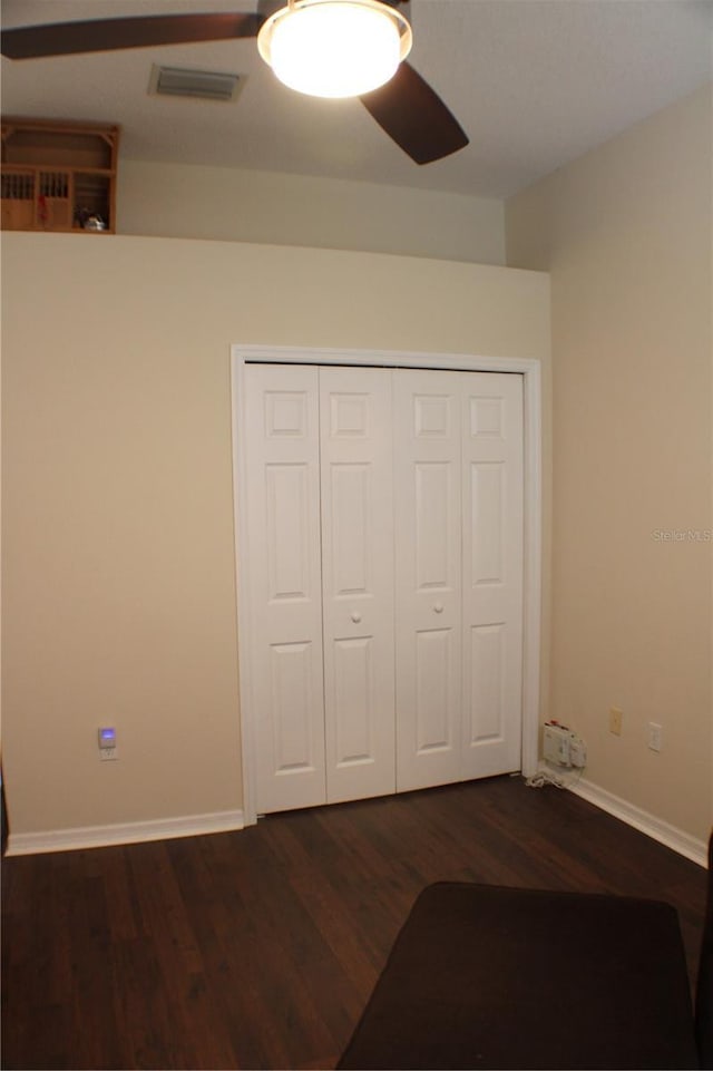 4837 Rainbow Race, New Port Richey, FL 34652 - unfurnished bedroom with dark wood-style floors, baseboards, a closet, and ceiling fan