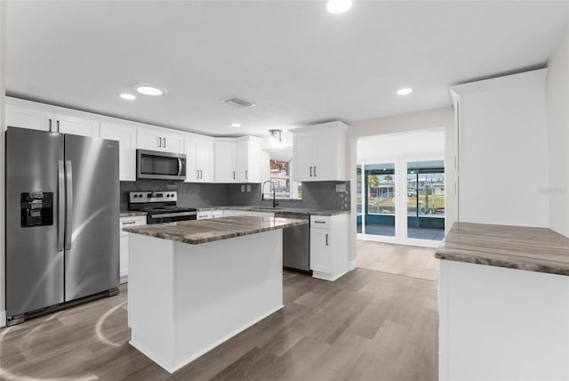13411 Lisa Dr, Hudson, FL 34667 - kitchen featuring appliances with stainless steel finishes, a sink, wood finished floors, tasteful backsplash, and recessed lighting