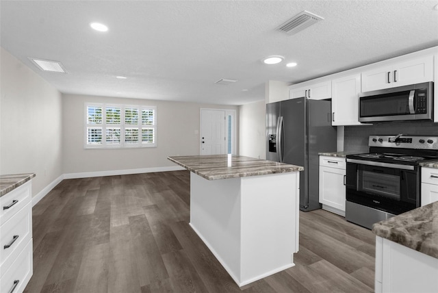13411 Lisa Dr, Hudson, FL 34667 - kitchen with stainless steel appliances, a center island, dark wood-style floors, stone counters, and recessed lighting