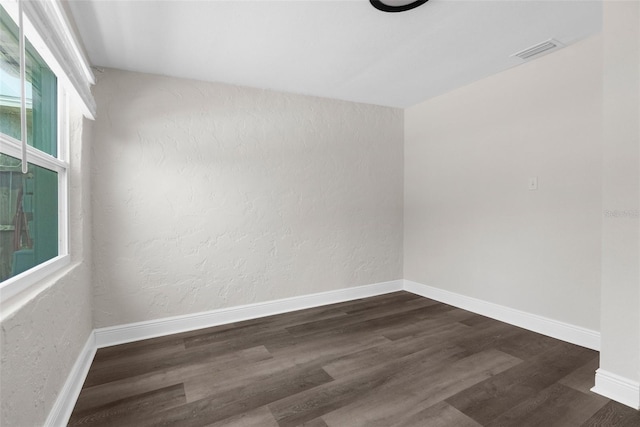 13411 Lisa Dr, Hudson, FL 34667 - unfurnished room featuring dark wood-style flooring, baseboards, and a textured wall