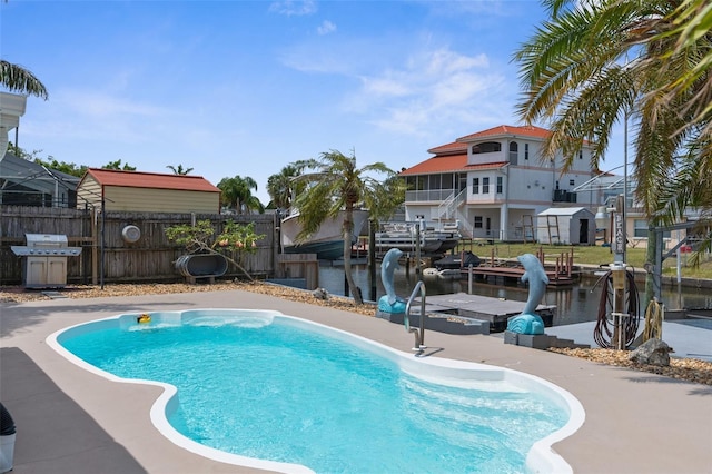 13411 Lisa Dr, Hudson, FL 34667 - view of swimming pool with a grill, fence, a water view, and a dock