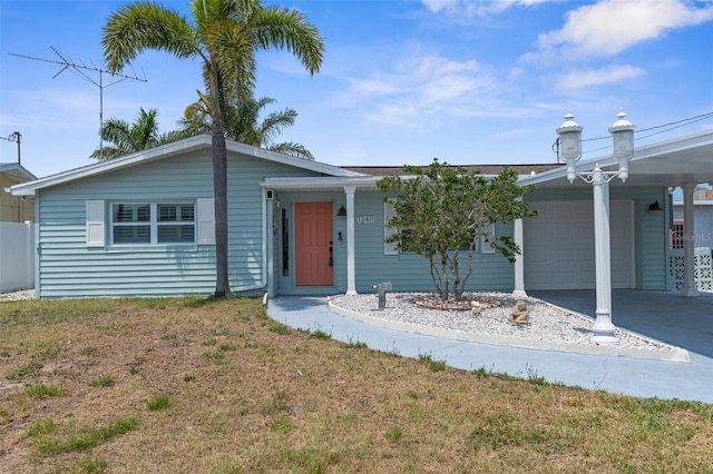 13411 Lisa Dr, Hudson, FL 34667 - ranch-style house with an attached garage, a carport, driveway, and a front lawn