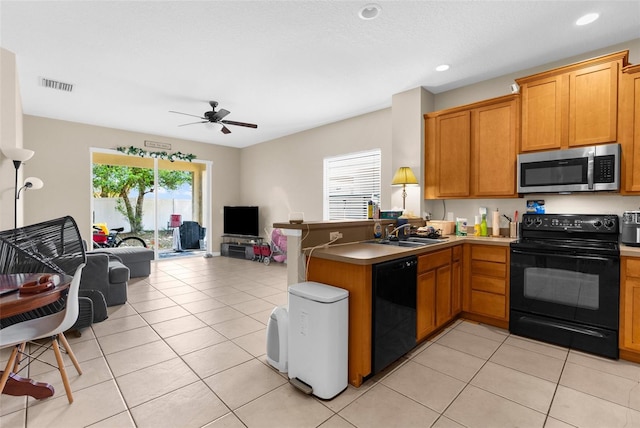 kitchen with black appliances, open floor plan, a peninsula, a sink, and ceiling fan