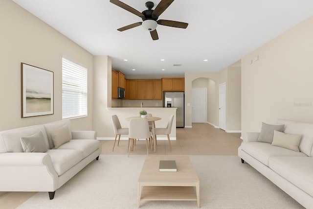 living area with arched walkways, ceiling fan, light tile patterned flooring, baseboards, and recessed lighting