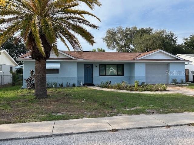 7331 Sandalwood Dr, Port Richey, FL 34668 - ranch-style house with an attached garage, stucco siding, and concrete driveway