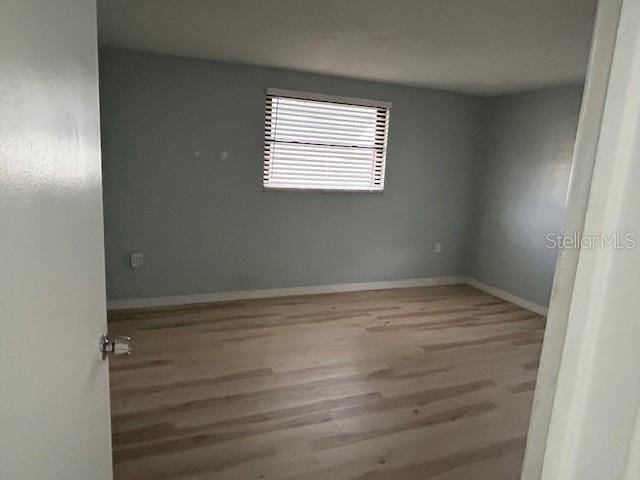 7331 Sandalwood Dr, Port Richey, FL 34668 - empty room featuring wood finished floors and baseboards