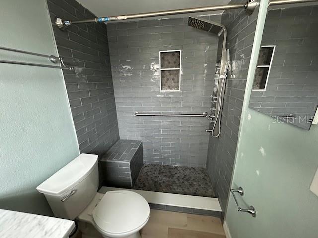 7331 Sandalwood Dr, Port Richey, FL 34668 - bathroom featuring a tile shower and toilet