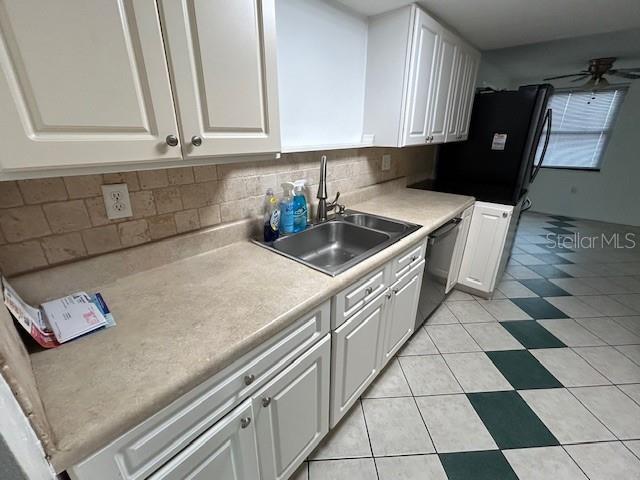 7331 Sandalwood Dr, Port Richey, FL 34668 - kitchen with dishwashing machine, white cabinetry, and a sink