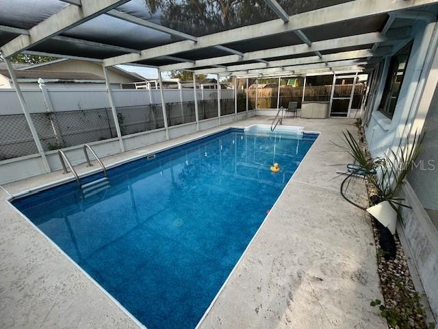 7331 Sandalwood Dr, Port Richey, FL 34668 - view of swimming pool with a fenced backyard, a patio, and glass enclosure
