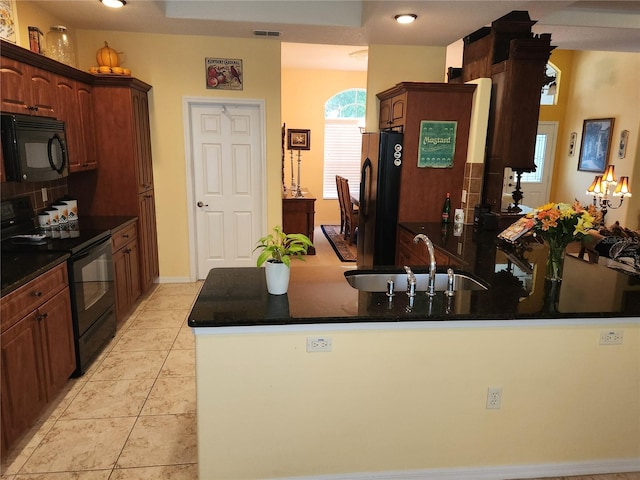 kitchen with black appliances, a sink, a peninsula, and light tile patterned floors