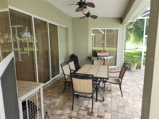 view of patio with a grill, a ceiling fan, and outdoor dining space