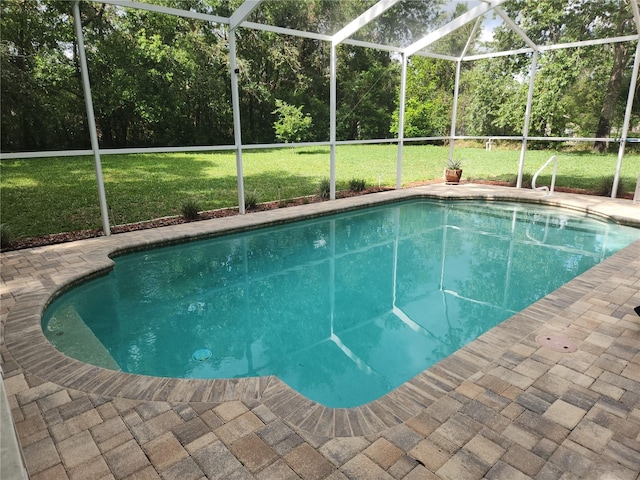 outdoor pool featuring a lawn, glass enclosure, and a patio