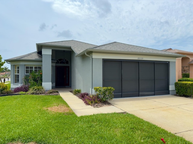 18109 Webster Grove Dr, Hudson, FL 34667 - view of front facade featuring concrete driveway, a garage, a front yard, stucco siding, and a shingled roof