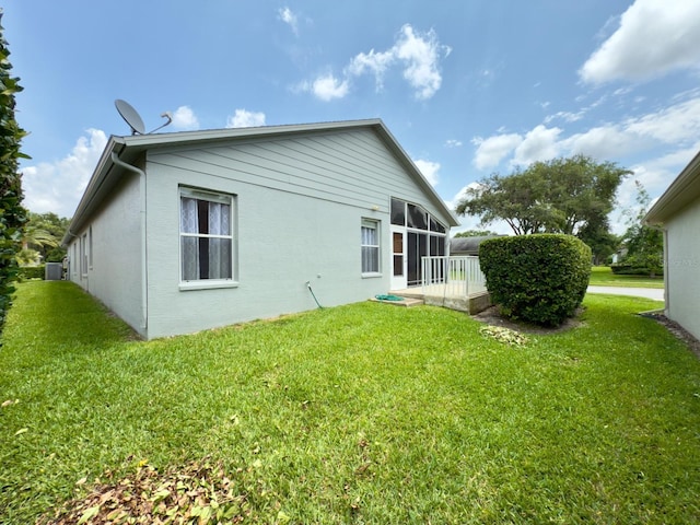 18109 Webster Grove Dr, Hudson, FL 34667 - back of house with a yard, stucco siding, and a sunroom