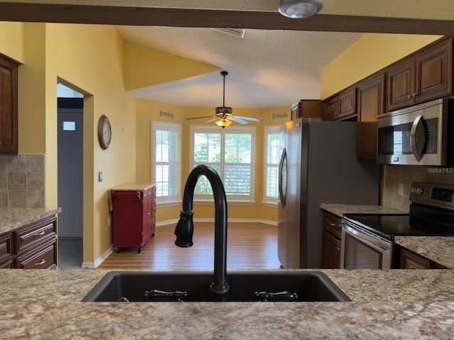 18109 Webster Grove Dr, Hudson, FL 34667 - kitchen featuring stainless steel appliances, a sink, tasteful backsplash, dark brown cabinetry, and ceiling fan