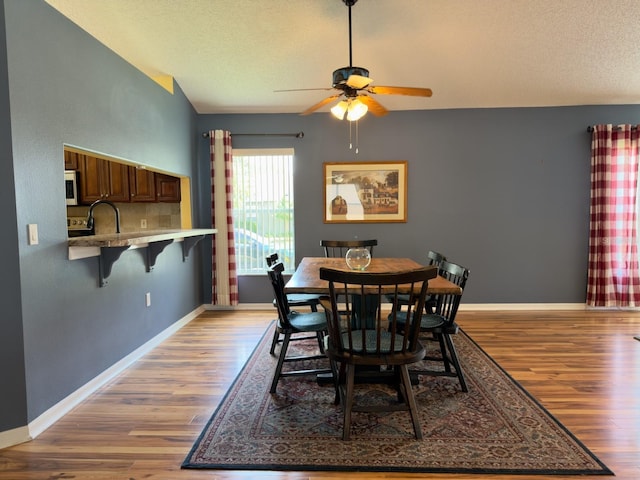 18109 Webster Grove Dr, Hudson, FL 34667 - dining space featuring light wood finished floors, ceiling fan, baseboards, and a textured ceiling