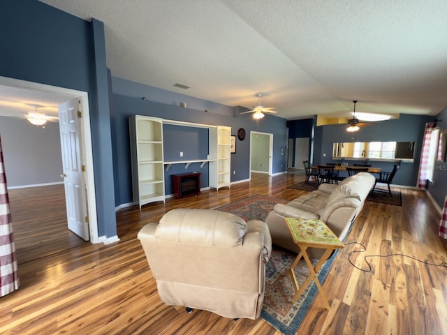 18109 Webster Grove Dr, Hudson, FL 34667 - living area with a ceiling fan, wood finished floors, a textured ceiling, lofted ceiling, and baseboards