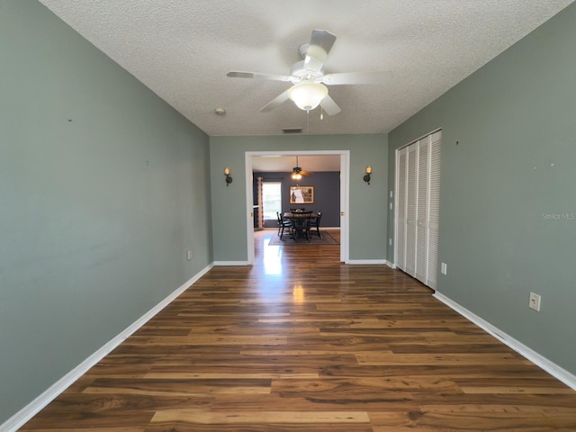 18109 Webster Grove Dr, Hudson, FL 34667 - spare room featuring a textured ceiling, wood finished floors, ceiling fan, and baseboards