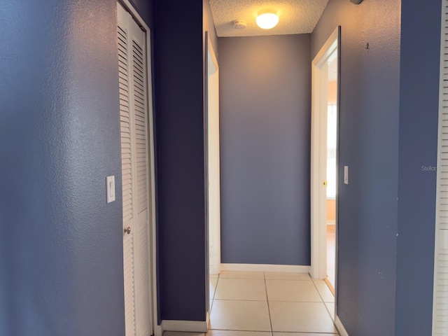 18109 Webster Grove Dr, Hudson, FL 34667 - hallway with light tile patterned floors, a textured ceiling, and baseboards