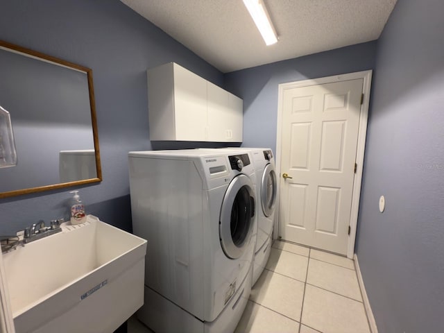 18109 Webster Grove Dr, Hudson, FL 34667 - washroom featuring washer and clothes dryer, cabinet space, a textured ceiling, light tile patterned flooring, and baseboards