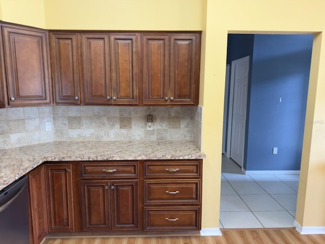 18109 Webster Grove Dr, Hudson, FL 34667 - kitchen featuring dishwasher, decorative backsplash, baseboards, light tile patterned floors, and light stone counters