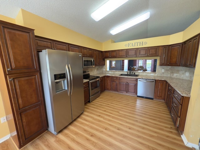 18109 Webster Grove Dr, Hudson, FL 34667 - kitchen with stainless steel appliances, light wood-style flooring, a textured ceiling, lofted ceiling, and decorative backsplash