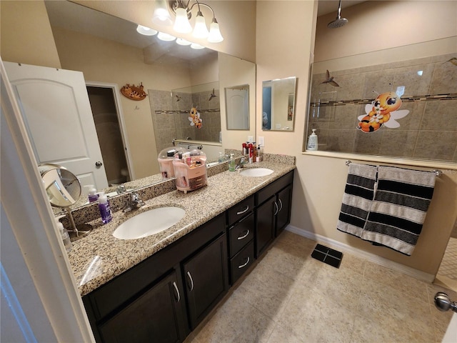full bath with a tile shower, double vanity, baseboards, and tile patterned flooring