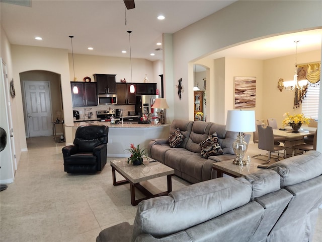 living room featuring arched walkways, a chandelier, and recessed lighting