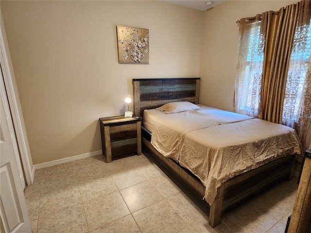 bedroom featuring light tile patterned floors and baseboards