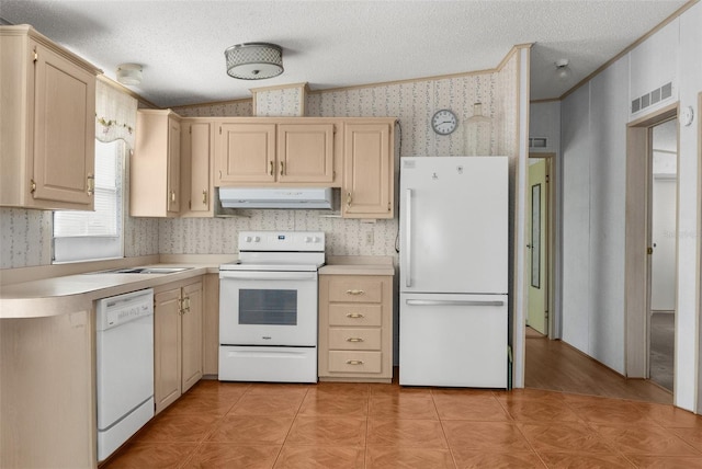 6802 Curlew Ln, Hudson, FL 34667 - kitchen with white appliances, wallpapered walls, under cabinet range hood, light brown cabinetry, and light countertops