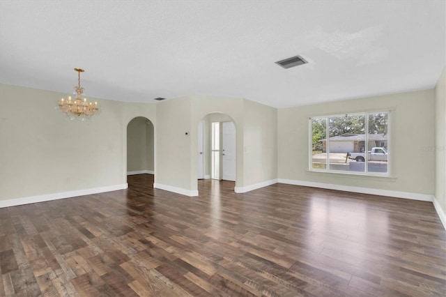 1402 Tallahassee Dr, Tarpon Springs, FL 34689 - unfurnished living room featuring arched walkways, wood finished floors, a chandelier, and baseboards