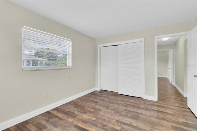 1402 Tallahassee Dr, Tarpon Springs, FL 34689 - unfurnished bedroom with wood finished floors, baseboards, and a closet