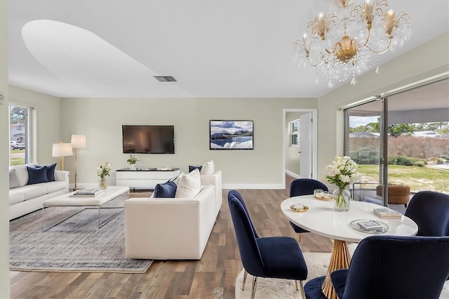 1402 Tallahassee Dr, Tarpon Springs, FL 34689 - living room with a chandelier, healthy amount of natural light, wood finished floors, and baseboards