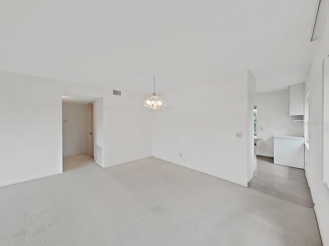 unfurnished room featuring a chandelier