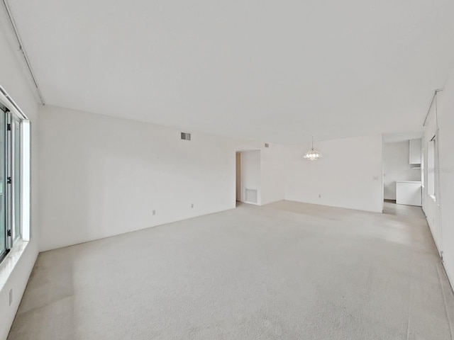 unfurnished living room featuring light colored carpet