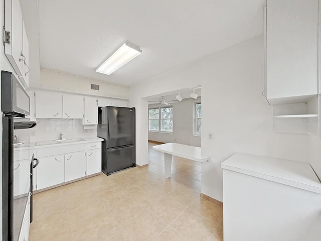 kitchen featuring black appliances, light countertops, a ceiling fan, light tile patterned flooring, and white cabinetry