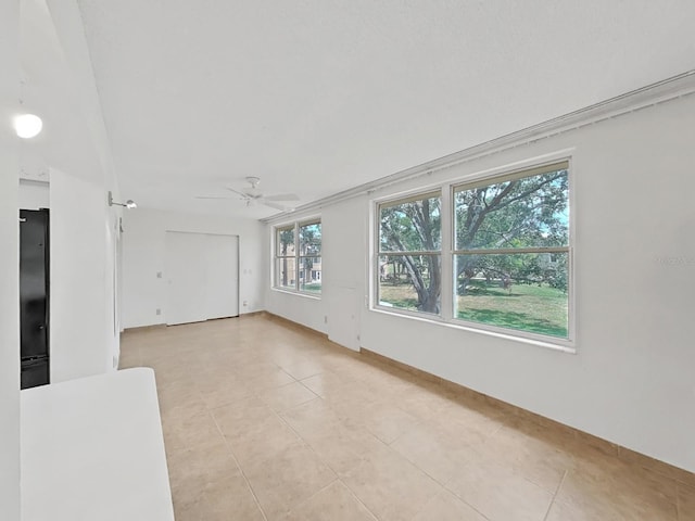 spare room with light tile patterned floors and ceiling fan