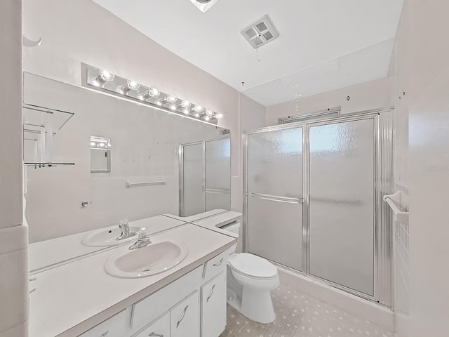 bathroom with a shower stall, tile patterned floors, vanity, and toilet
