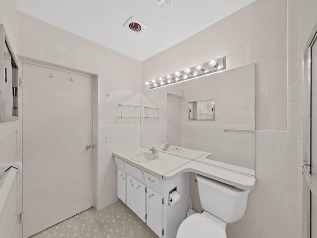 bathroom with tile walls, toilet, and vanity