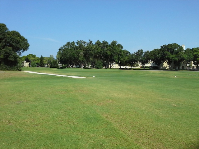 view of property's community featuring golf course view and a lawn