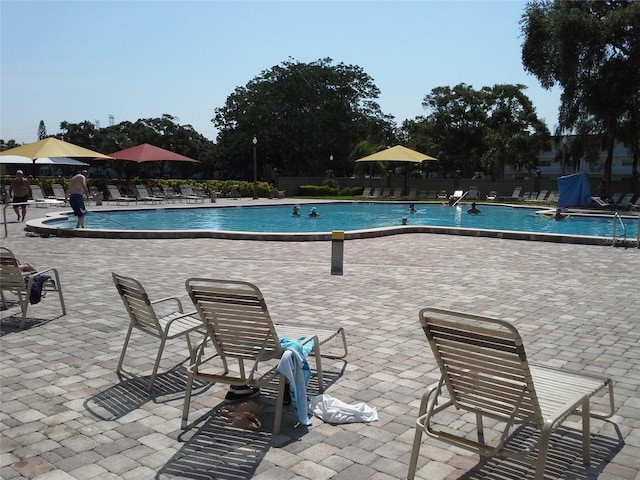 community pool featuring fence and a patio