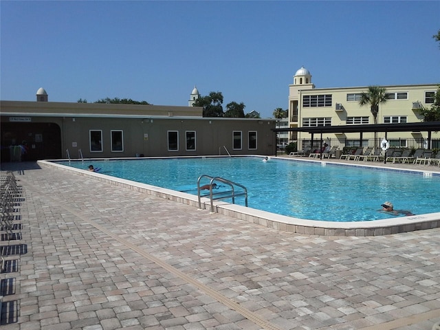community pool with fence and a patio