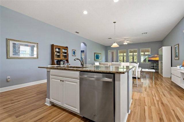 11401 Quiet Forest Dr, Tampa, FL 33635 - kitchen featuring stainless steel dishwasher, a sink, arched walkways, light wood-style floors, and white cabinets