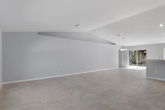 spare room with a chandelier, lofted ceiling, and baseboards