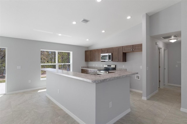 kitchen with stainless steel appliances, light countertops, vaulted ceiling, a sink, and baseboards