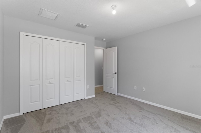 unfurnished bedroom with carpet flooring, a closet, and baseboards