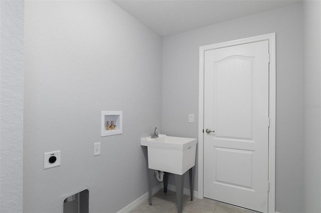 clothes washing area with hookup for an electric dryer, hookup for a washing machine, light tile patterned floors, and baseboards