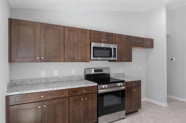12192 Eskimo Curlew Rd, Weeki Wachee, FL 34614 - kitchen featuring appliances with stainless steel finishes, light countertops, baseboards, dark brown cabinetry, and light tile patterned flooring